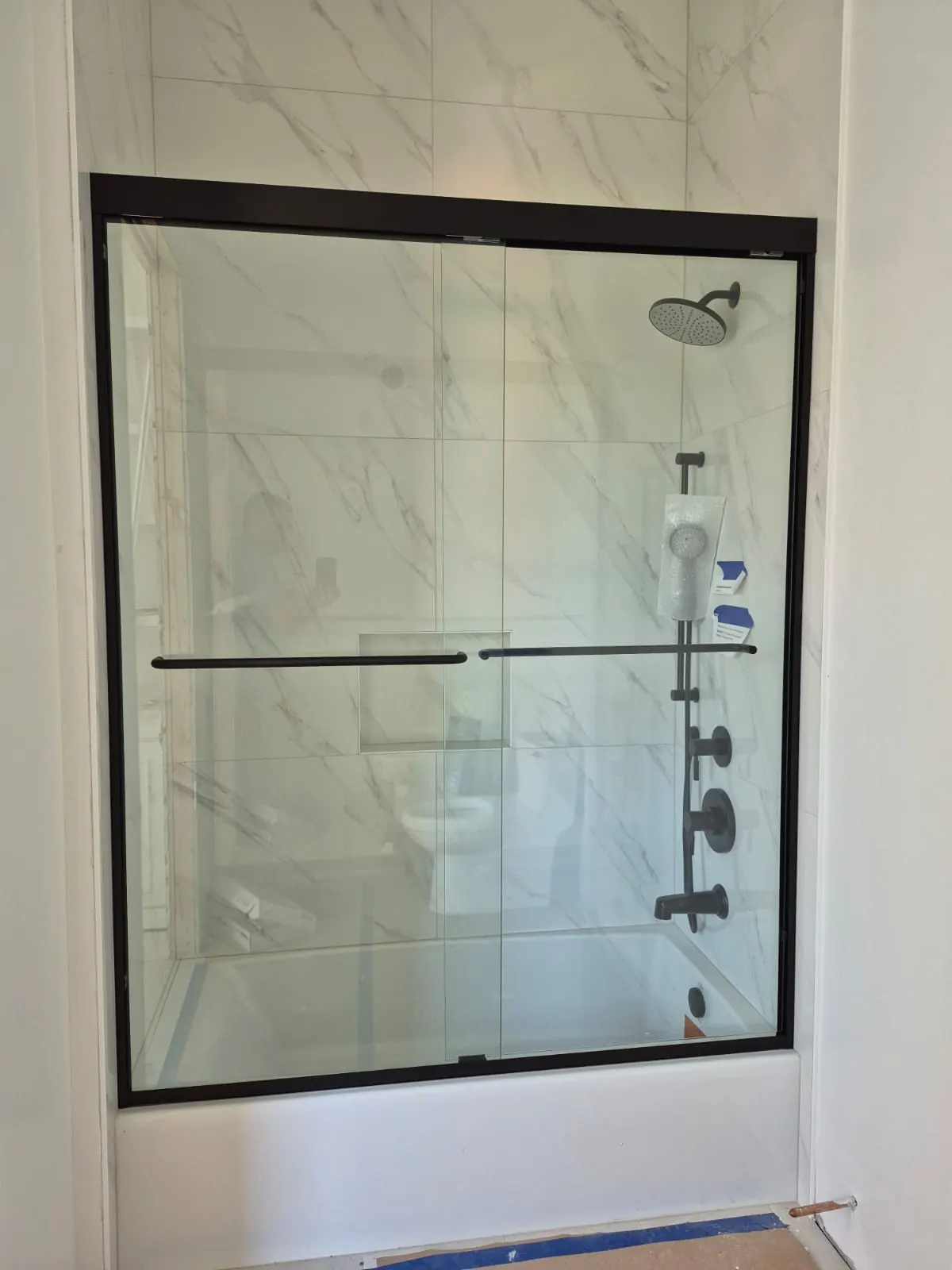 after framed sliding shower glass with black hardware in Southwest Florida