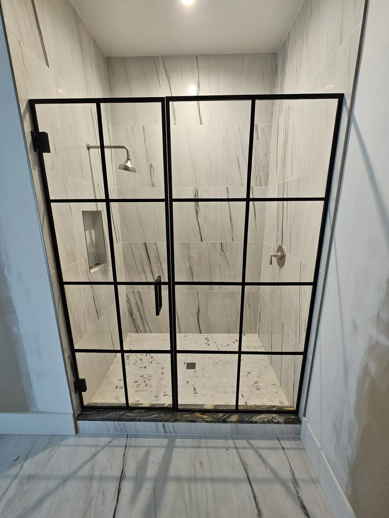 after framed swing shower glass with black hardware in Southwest Florida