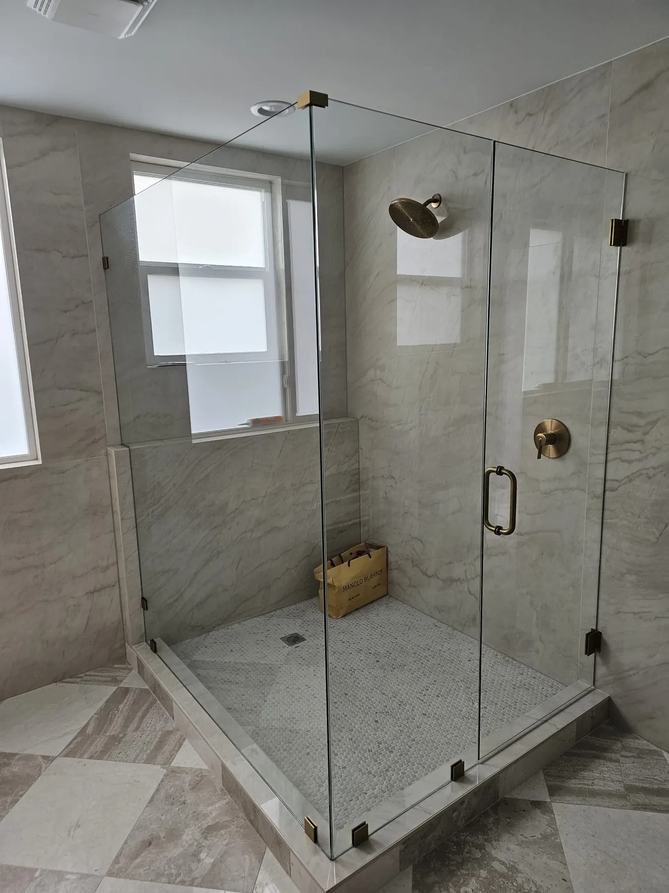 after frameless swing shower glass with brushed gold hardware in Southwest Florida