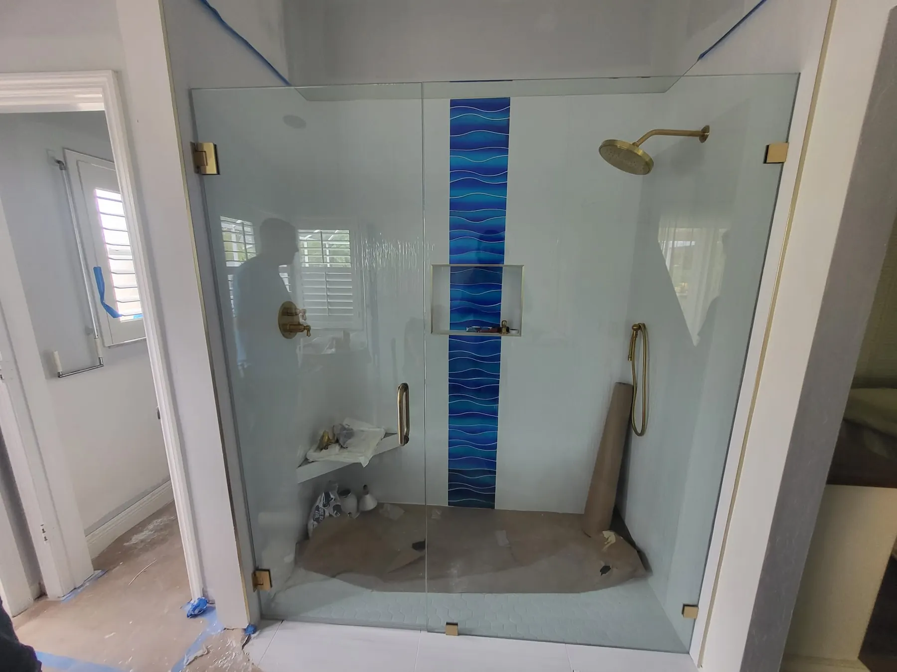 after frameless swing shower glass with brushed gold hardware in Southwest Florida