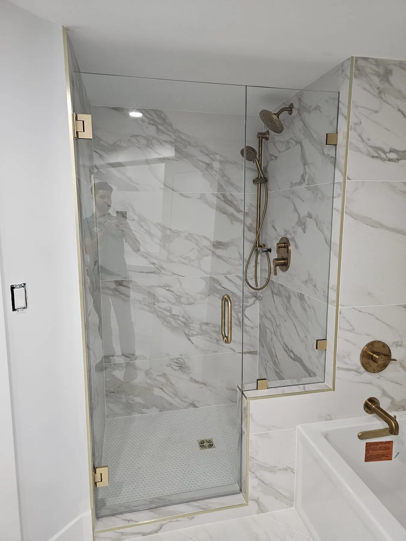 after frameless swing shower glass with brushed gold hardware in Southwest Florida