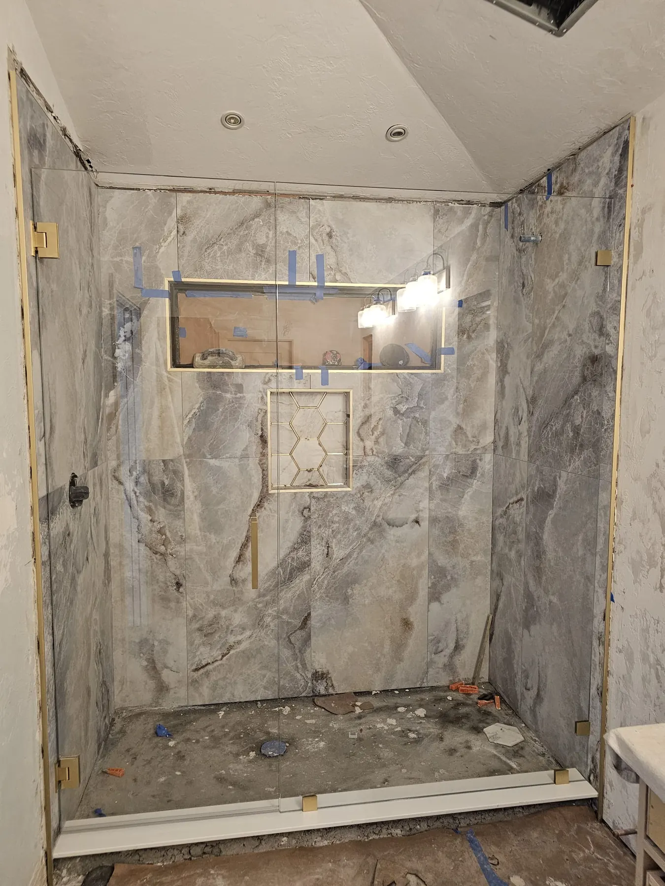 after frameless shower glass with brushed gold hardware in Southwest Florida