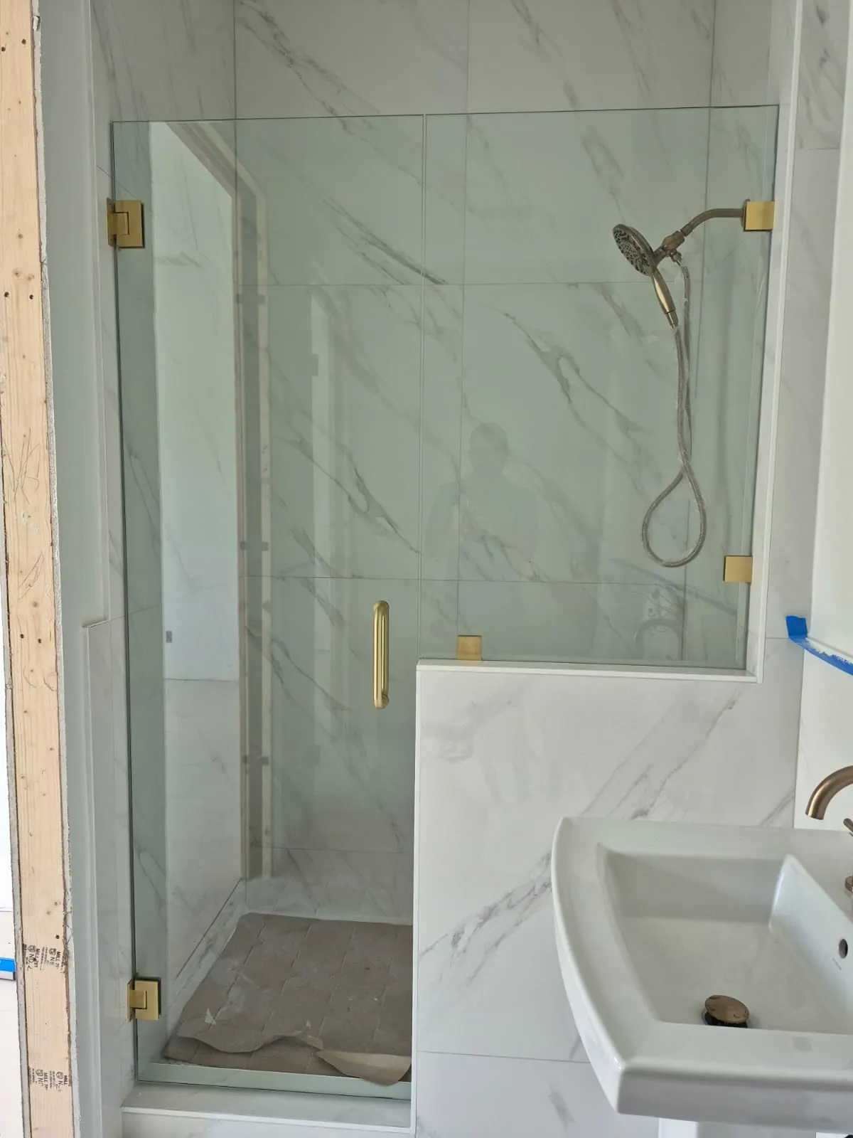 after frameless swing shower glass with brushed gold hardware in Southwest Florida
