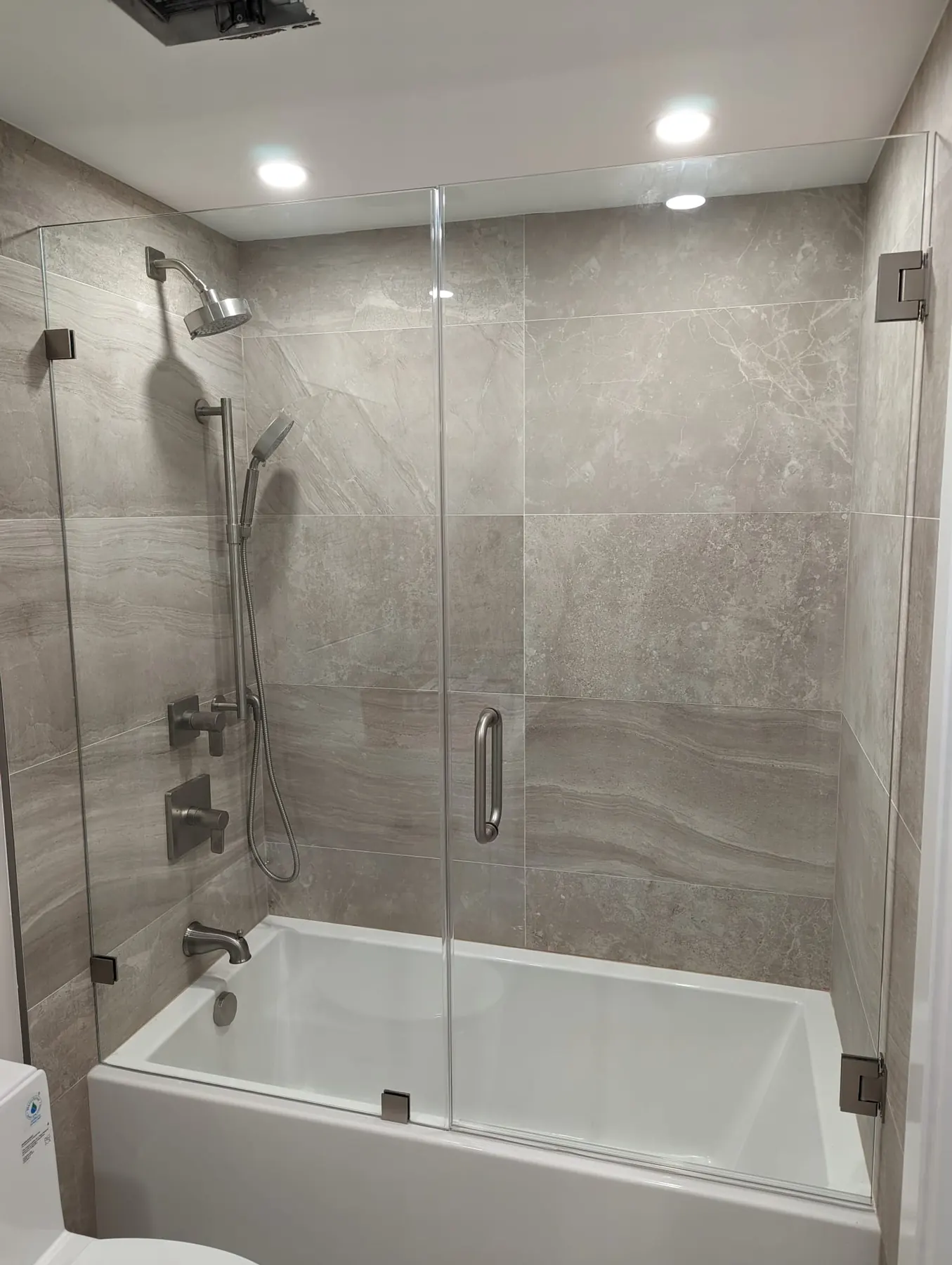 after frameless swing shower glass with brushed nickel hardware in Southwest Florida