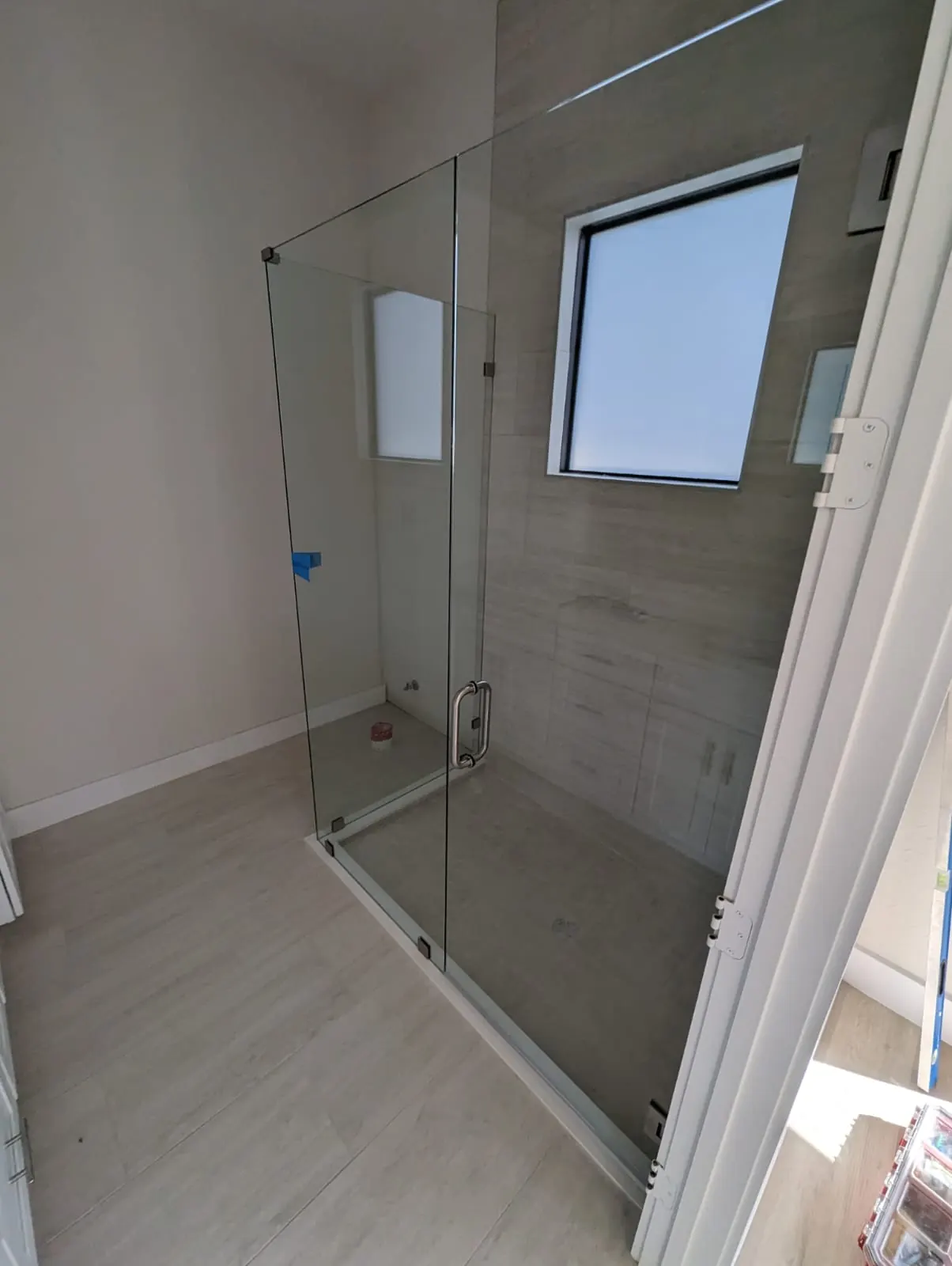 after frameless swing shower glass with brushed nickel hardware in Southwest Florida